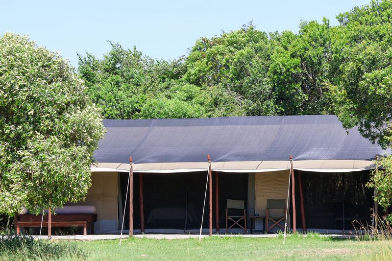 Safari tent exterior in a green garden at a tented camp